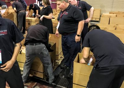 Team members putting backpacks into Java City boxes