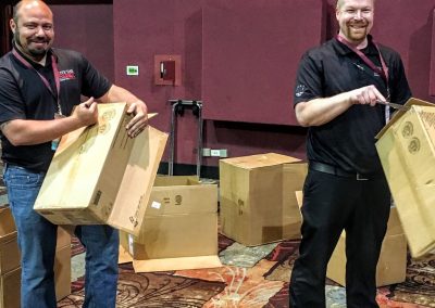 two team members breaking down boxes
